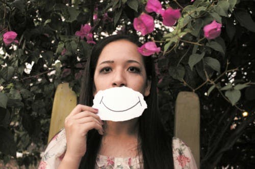 first-gen-latina-college-student-pressure-and-pride-smiling-and-frowning-in-front-of-flowers